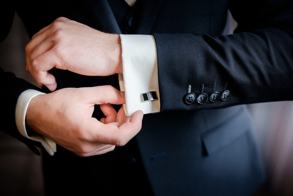 man adjusting cufflinks on shirt